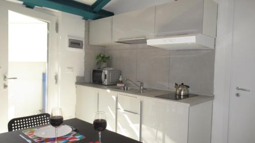 a kitchen with a sink and a table with wine glasses at Appartamenti Borghetto San Donato 105 in Bologna