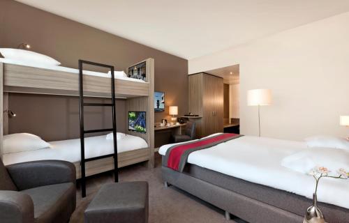 ein Hotelzimmer mit 2 Etagenbetten und einem Stuhl in der Unterkunft Fletcher Hotel-Restaurant Wings-Rotterdam in Rotterdam