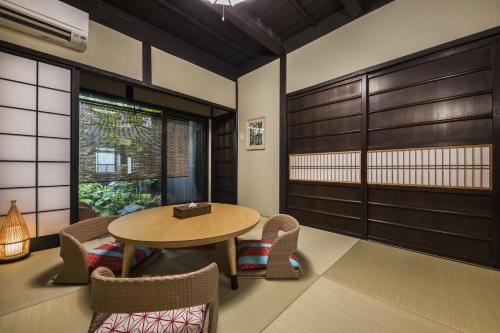 a room with a table and chairs and a window at Shiki Homes KYOKA in Kyoto
