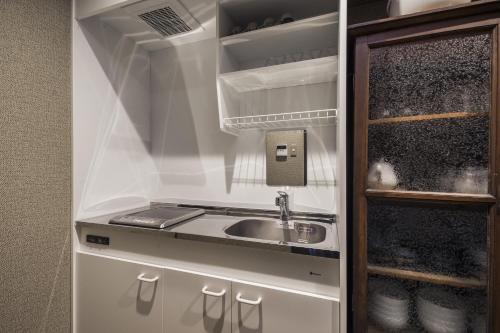 a kitchen with a sink in a refrigerator at Shiki Homes KYOKA in Kyoto
