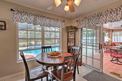 a dining room with a table and chairs and windows at Centrally Located Deltona Home with Pool and Yard in Deltona