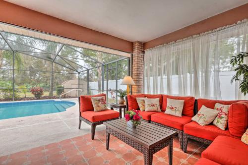 a living room with a red couch and chairs and a pool at Centrally Located Deltona Home with Pool and Yard in Deltona