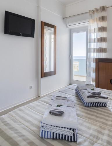 a bedroom with two towels on a bed with a television at Volcanic Ocean View (Ponta Delgada historic center) in Ponta Delgada