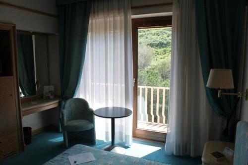 a hotel room with a window with a chair and a table at 501 Hotel in Vibo Valentia