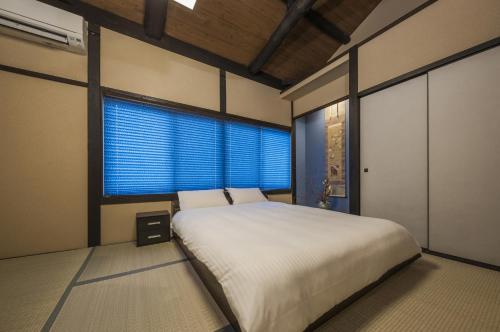 a bedroom with a large bed and a large window at Shiki Homes KYOKA in Kyoto