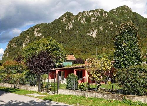 ein Haus vor einem Berg mit einem Zaun in der Unterkunft Villa Stefano in Crone