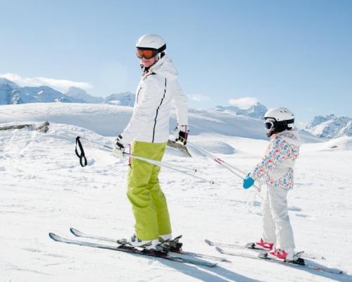 una mujer y un niño esquiando en la nieve en Appartamento N. 1, en Livinallongo del Col di Lana