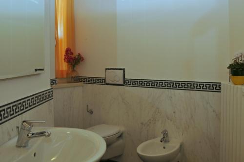 ein Badezimmer mit einem Waschbecken, einem WC und einem Spiegel in der Unterkunft Vico Sweet mountain view in Crone