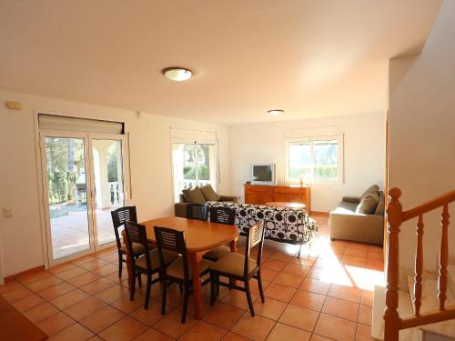 a living room with a table and chairs and a couch at Villa Villa Alguer by Interhome in Les tres Cales