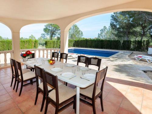 a dining room with a table and chairs and a pool at Villa Villa Alguer by Interhome in Les tres Cales