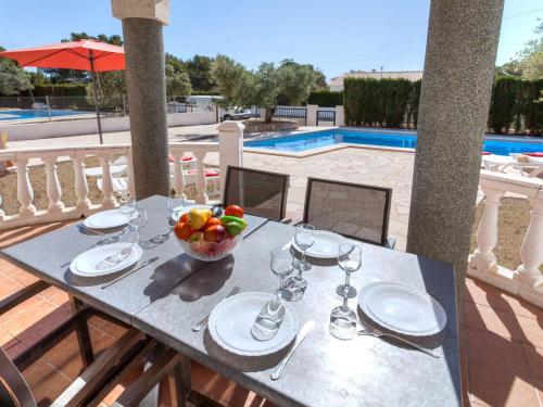 a table with a bowl of fruit on top of a patio at Villa Villa Cala Vidre A by Interhome in Les tres Cales