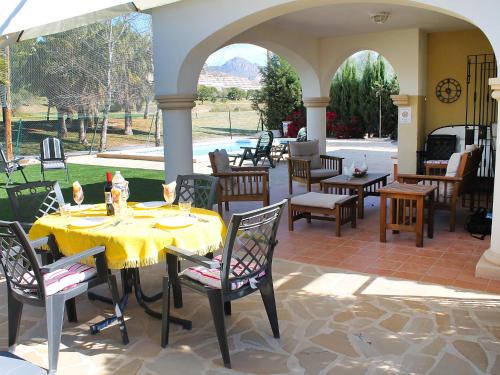 an outdoor patio with a table and chairs and an archway at Holiday Home Bonalba Golf- Urb- Los Naranjos by Interhome in Muchamiel