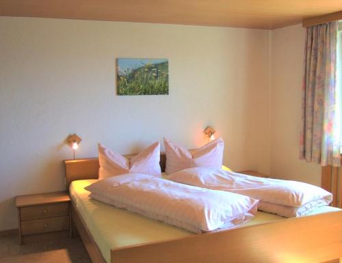 1 Schlafzimmer mit 2 Betten mit weißer Bettwäsche und Kissen in der Unterkunft Haus Adlerhorst in Sulzberg