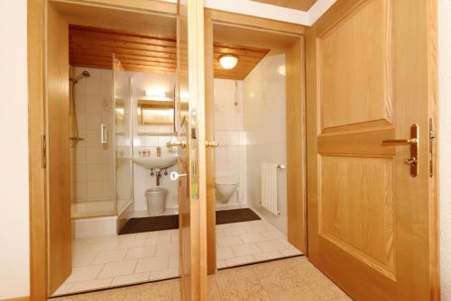 La salle de bains est pourvue de toilettes et d'une porte en verre. dans l'établissement Haus Adlerhorst, à Sulzberg
