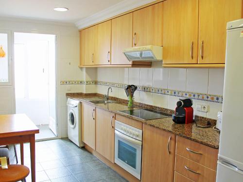 una cucina con armadi in legno, lavandino e lavastoviglie di Apartment Lo Morant Costa Alicante by Interhome ad Alicante