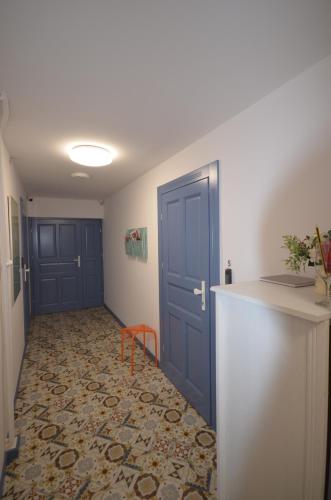 an empty hallway with a blue door and a table at Blue Sail Sopot Apartments in Sopot