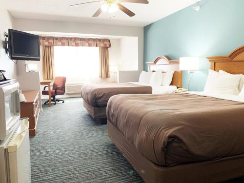 a hotel room with two beds and a flat screen tv at BridgePointe Inn & Suites by BPhotels, Lincoln I-80 & 27th St in Lincoln