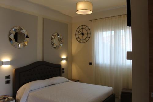 a bedroom with a bed and clocks on the wall at Villa Martina Luxury Rooms in Desenzano del Garda