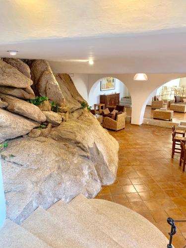 a living room with a large rock wall at Green Park Hotel in Porto Cervo
