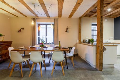 une cuisine et une salle à manger avec une table et des chaises en bois dans l'établissement LA GRANGE D'ELISA, à Epfig