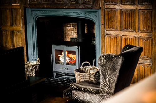 a living room with a fireplace and a fire place at Seckford Hall Hotel & Spa; BW Premier Collection in Woodbridge