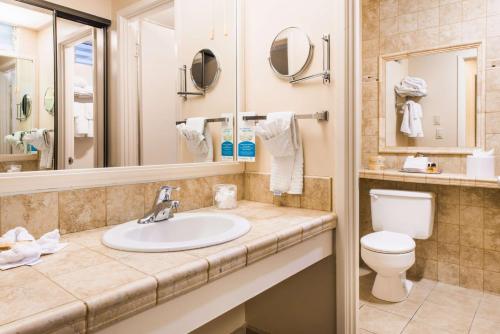 a bathroom with a sink and a toilet and a mirror at Best Western Plus Pepper Tree Inn in Santa Barbara