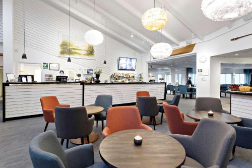 a restaurant with tables and chairs and a bar at Best Western Hotel Corallen in Oskarshamn