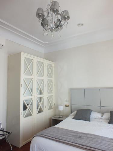 a bedroom with a large bed and a chandelier at Casa Palacio VillaZambra in Ronda
