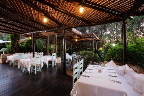 un comedor con mesas blancas y sillas blancas en Green Park Hotel en Porto Cervo