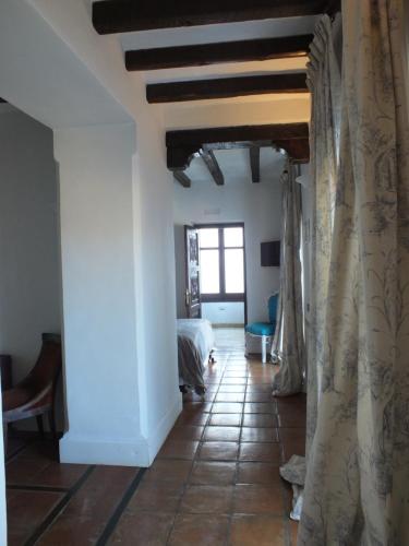 a hallway with a room with a bed and curtains at Casa Palacio VillaZambra in Ronda
