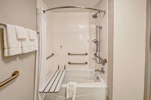 a white bath tub in a bathroom with towels at Holiday Inn Express Hotel & Suites Jackson Northeast by IHG in Jackson