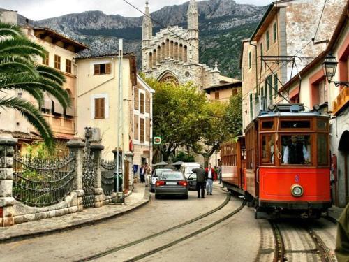 a red tram on a street in a city at Villa Dinastía Resort Lujo in Llucmajor