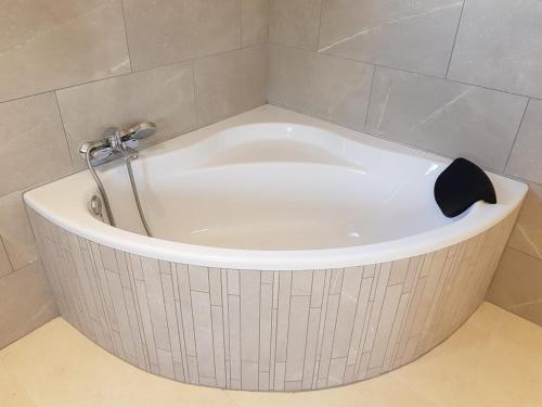 a white bath tub with a shower in a bathroom at Villa Dinastía Resort Lujo in Llucmajor