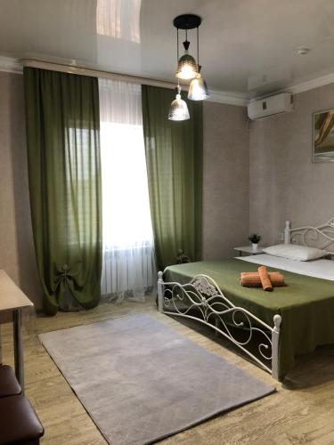 a bedroom with a green bed and a window at Hotel Barhat Аktobe in Aktobe