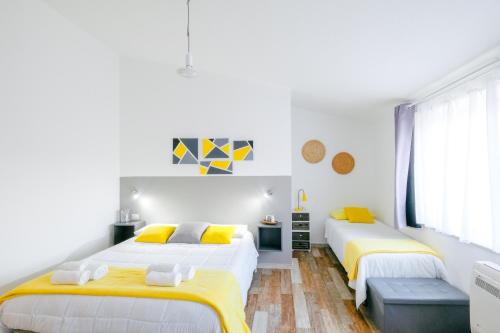 two beds in a room with white and yellow at B&B Fradama' Holiday in Dorgali