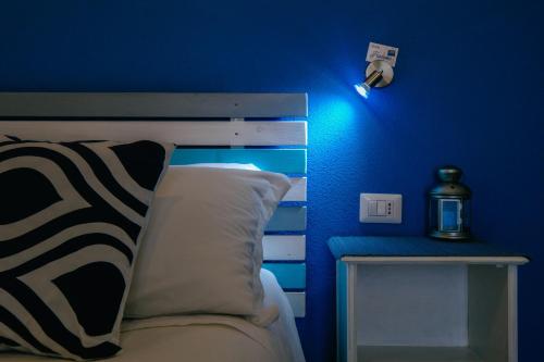 Dormitorio azul con cama y pared azul en B&B Fradama' Holiday, en Dorgali