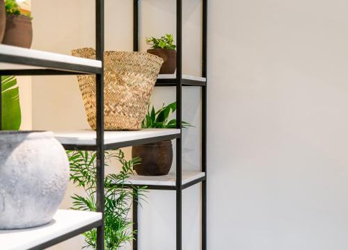 a black shelving unit with potted plants on it at Hotel Eden Nord Soller in Port de Soller