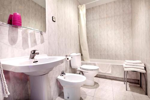 a bathroom with a sink and a toilet and a bath tub at HOTEL FORNOS - Barcelona in Barcelona