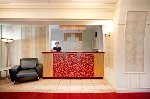 マグニトゴルスクにあるAvrora Hotelのホテルロビーのバーに座る女性