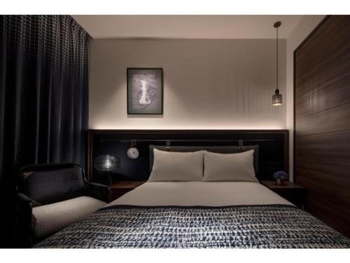 a bedroom with a large bed and a chair at THE LIVELY AZABUJUBAN TOKYO / Vacation STAY 77702 in Tokyo