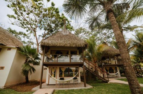 a resort with two huts and palm trees at El Sauce Resort - Hotel Asociado Casa Andina in Sauce