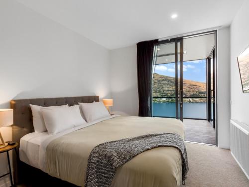 een slaapkamer met een groot bed en een balkon bij Sierra Views - Queenstown Holiday Home in Queenstown