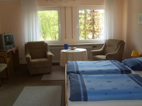 a bedroom with two beds and two chairs and a table at Ferienhof Temme in Bad Rothenfelde