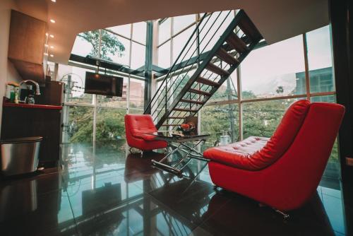 salon z 2 czerwonymi krzesłami i schodami w obiekcie Provenza Lofts w mieście Medellín