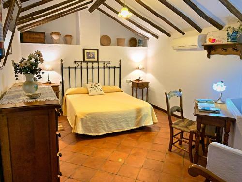 - une chambre avec un lit, une table et des chaises dans l'établissement Acogedora casa rural en Zahara de la Sierra, à Zahara de la Sierra