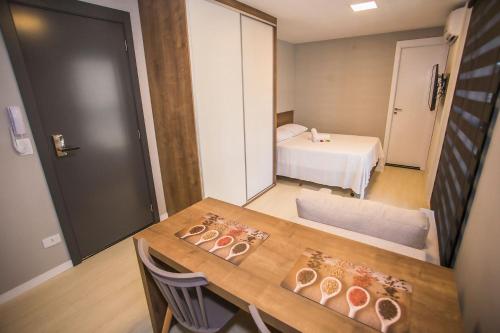 a room with a table and a room with a bed at Studio Central com Ar Condicionado - ALL0817 in Curitiba