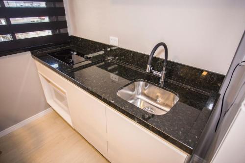 a kitchen with a sink and a counter top at Studio Central com Ar Condicionado - ALL0817 in Curitiba