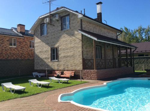 a house with a swimming pool in front of a house at Pilot Guest House - Domodedovo in Domodedovo