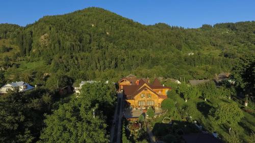 an aerial view of a house in the middle of a mountain at Хата Різьбяра in Beloberëzka