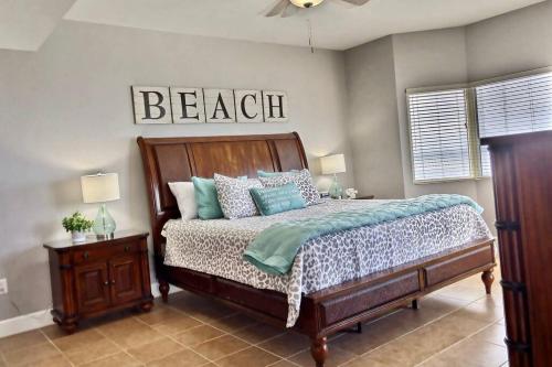 ein Schlafzimmer mit einem Bett und einem Schild, das den Strand liest in der Unterkunft Happy Ours 2200 sq ft corner beachfront sleeps 12 in Panama City Beach